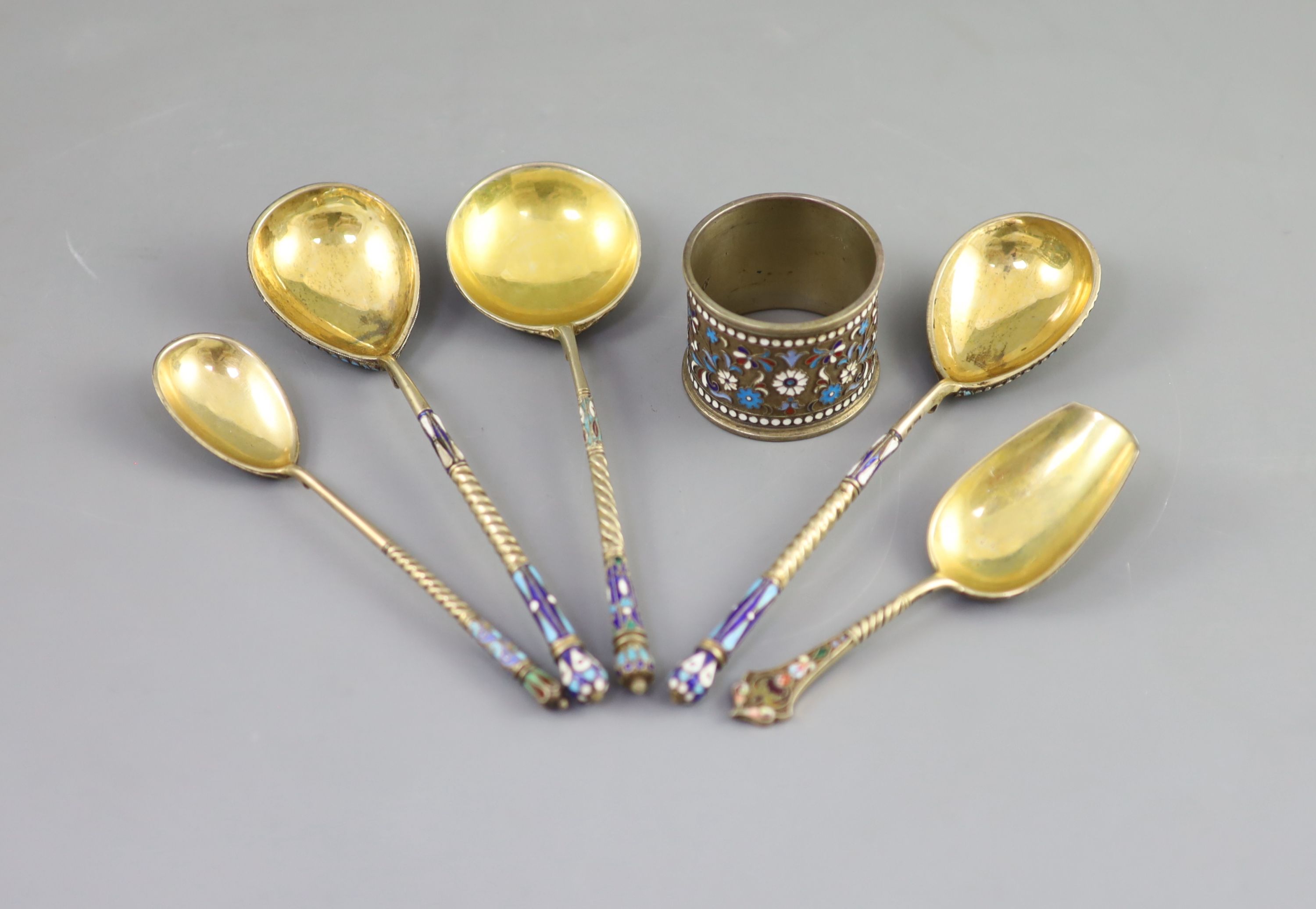 Five assorted late 19th/early 20th century Russian 84 zolotnik silver gilt and cloisonne enamel spoons and a similar napkin ring